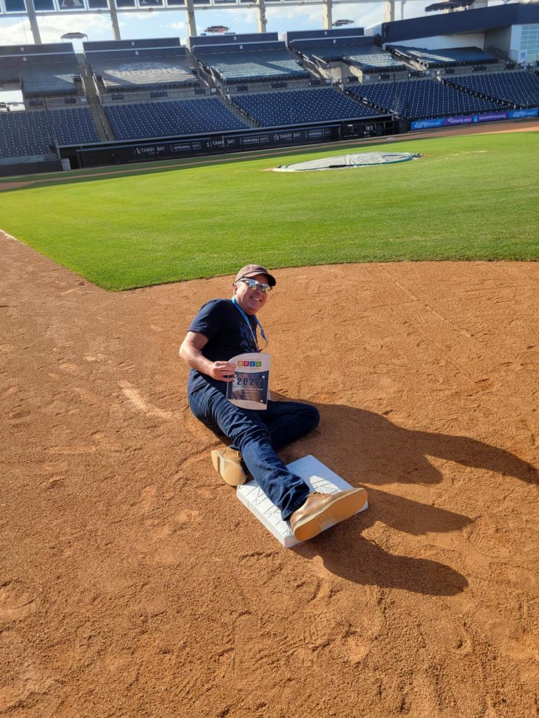 Person sliding onto first base with award in hand