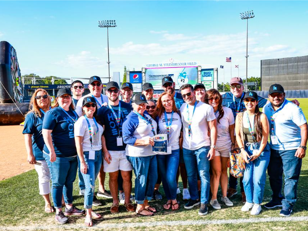 Group of Tampa Bay employees accepting award on baseball field